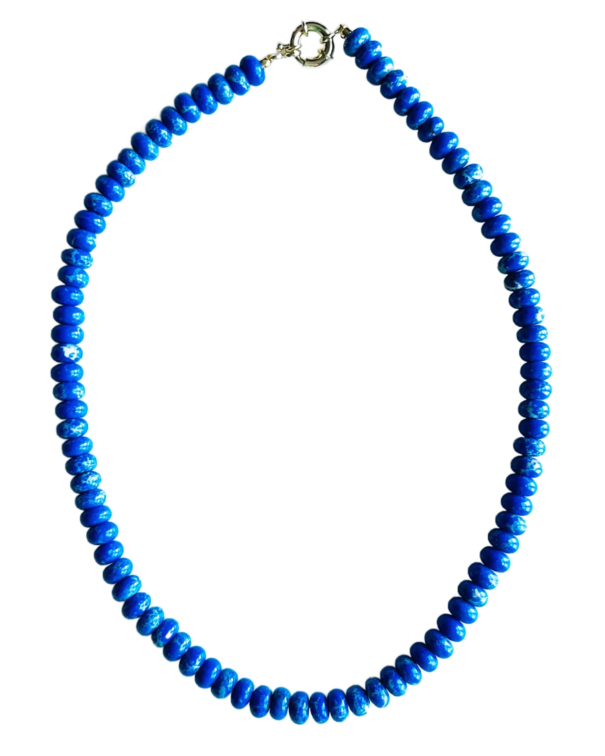 The Blue Jasper Candy Necklace by Faire is a handmade piece featuring bright blue gemstone beads in a single strand, finished with an 18kt gold plated clasp, and displayed on a white background.