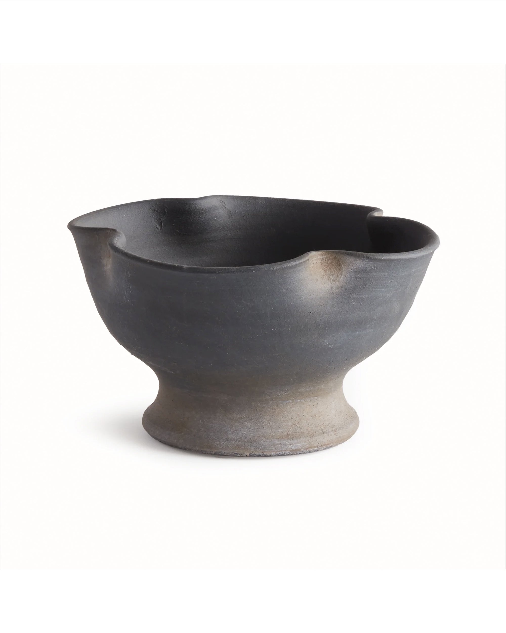 The N4TQ10 Kaloa Bowl by Napa Home & Garden is a handcrafted black ceramic piece with a cold finish, featuring an uneven wavy rim and wide rounded base—ideal for display against any plain white background.
