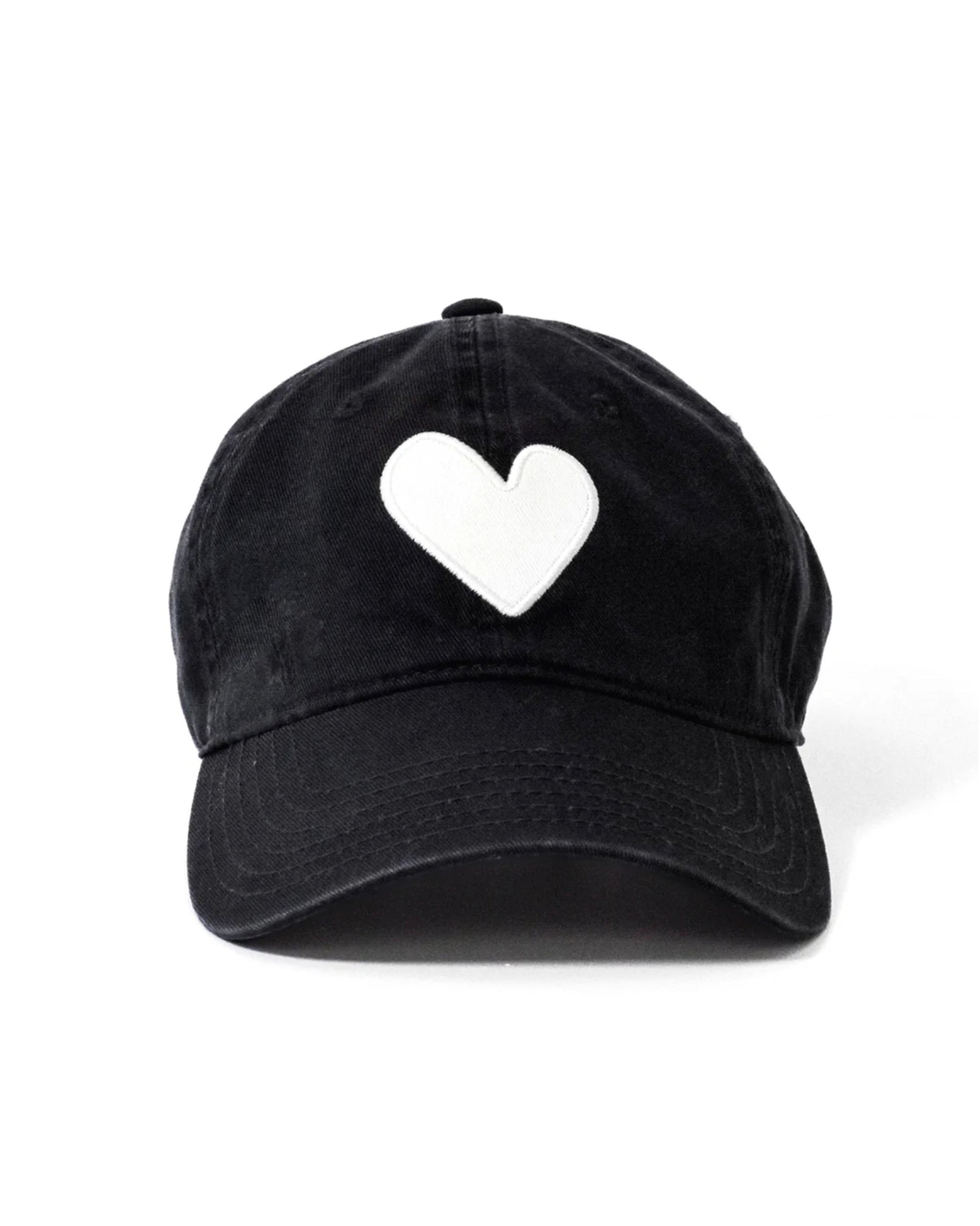 The Kerri Rosenthal Baseball Hat Heart Patch features a black design with an embroidered heart-shaped patch on the front, shown against a plain white background for a stylish, modern look.