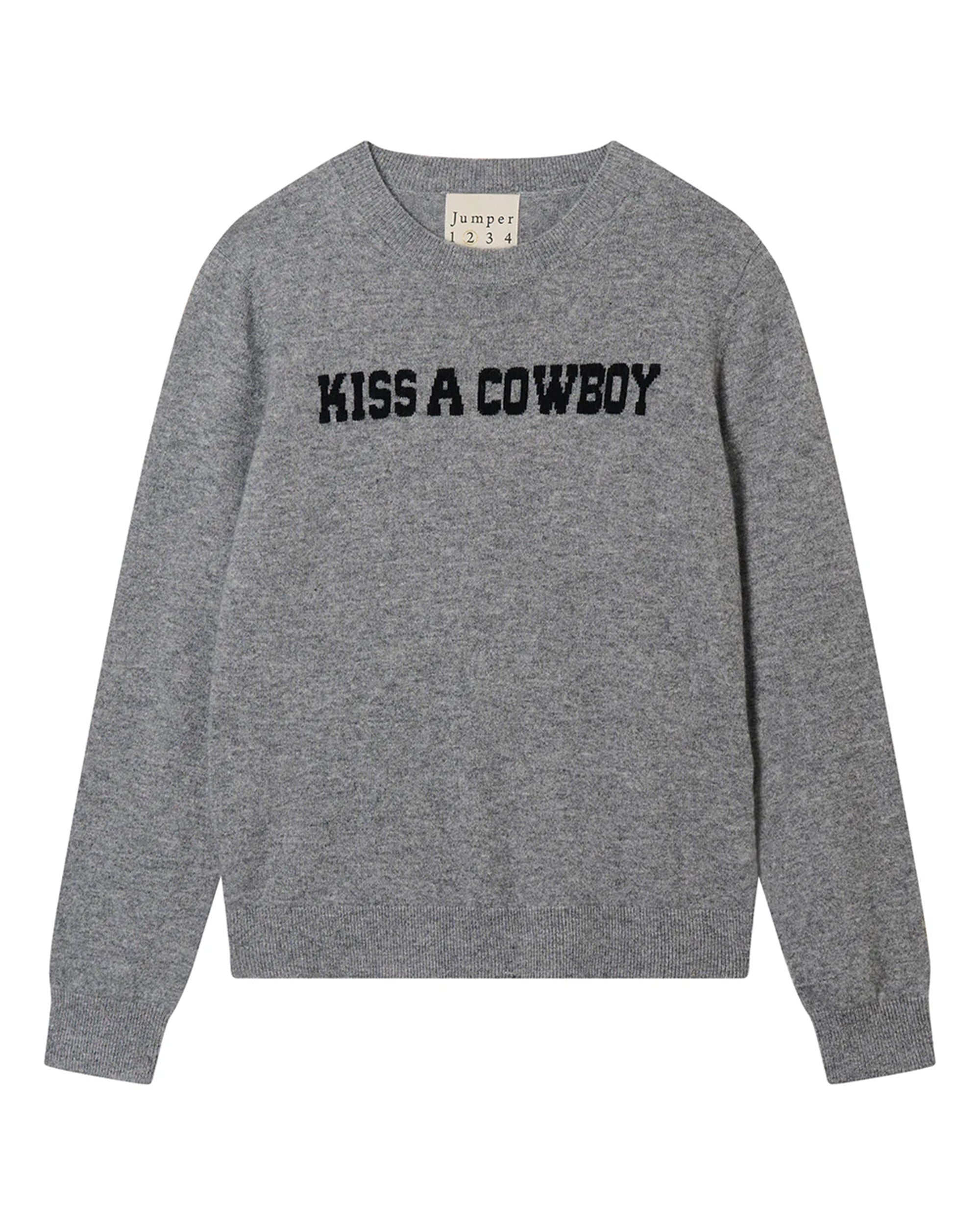 The Kiss A Cowboy Crew by Jumper 1 2 3 4/CR2 is a grey crew neck jumper with bold black “KISS A COWBOY” lettering on the chest, finished with ribbed cuffs and hem for a classic, cozy look.