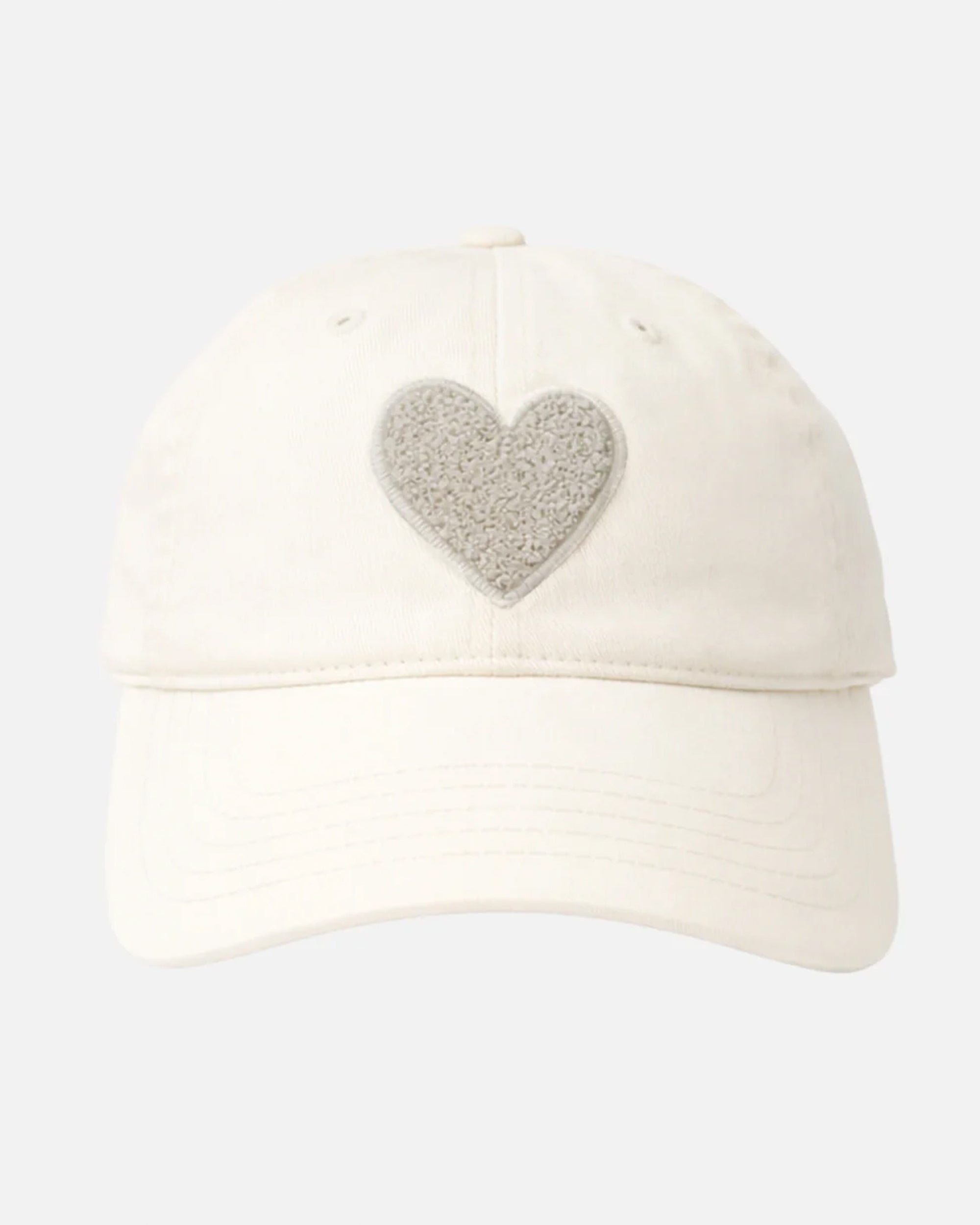 The KR Chenille Heart Hat by Kerri Rosenthal is a cream cotton-twill cap with an adjustable fit and textured gray heart patch on the front, shown here against a plain light gray background.