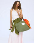 KR Imperfect Heart Tote with orange scarf, styled by a woman in white dress and green sweater, by Kerri Rosenthal.