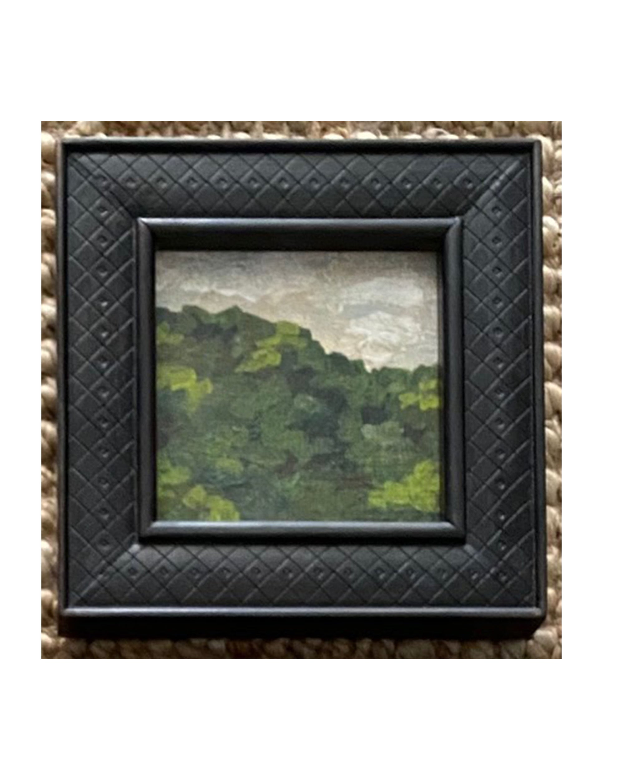 Tak Design’s LANDSCAPES Framed Art features a hand-painted green hill under a cloudy sky, set in a square, textured black frame—an ideal accent to bring charm to your home decor.