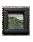 Tak Design’s LANDSCAPES Framed Art features a hand-painted green hill under a cloudy sky, set in a square, textured black frame—an ideal accent to bring charm to your home decor.