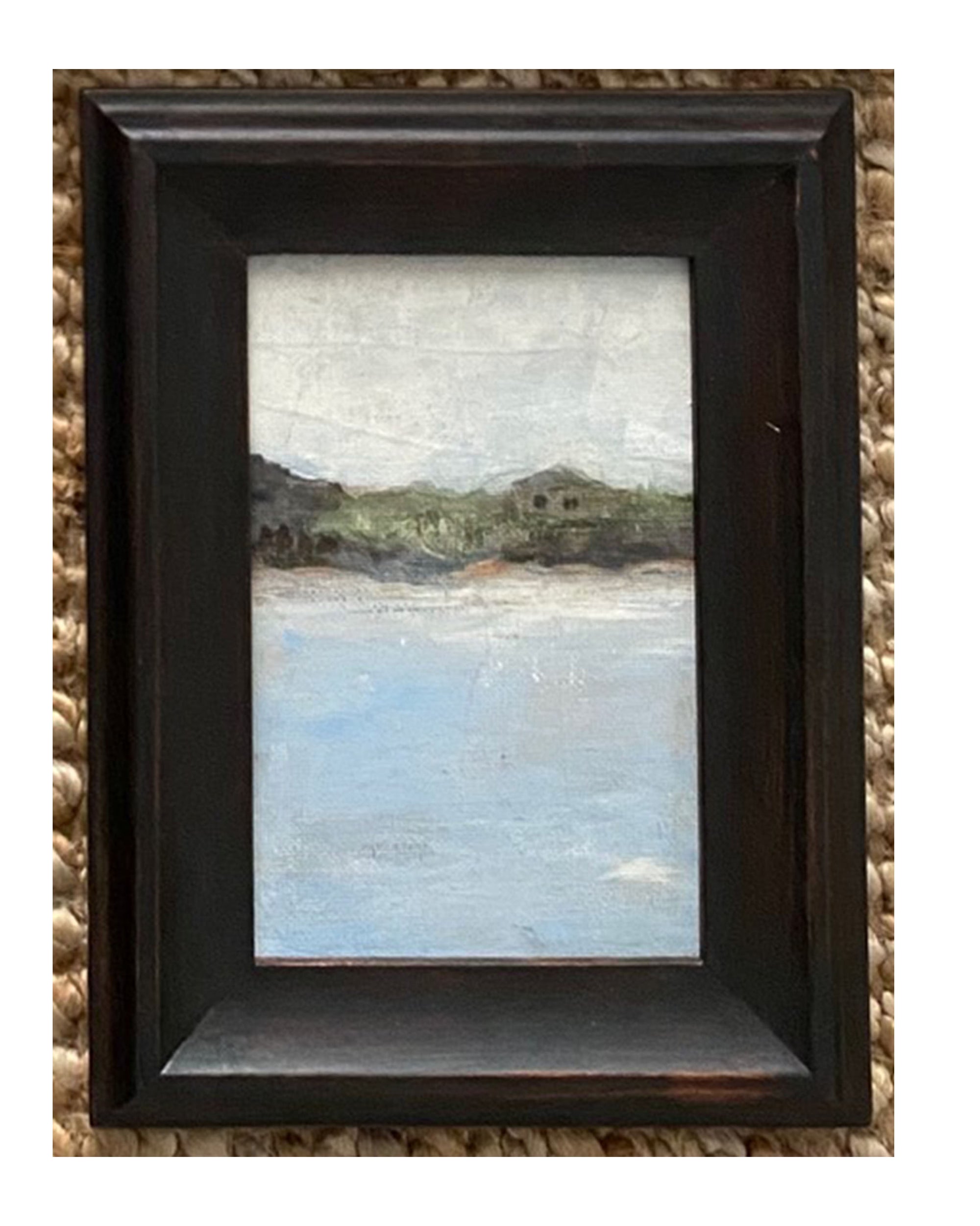 The Tak Design LANDSCAPES Framed Art features a peaceful scene with water, trees, a house, and a pale sky. Its dark vintage frame adds timeless charm, making it an ideal home decor piece.