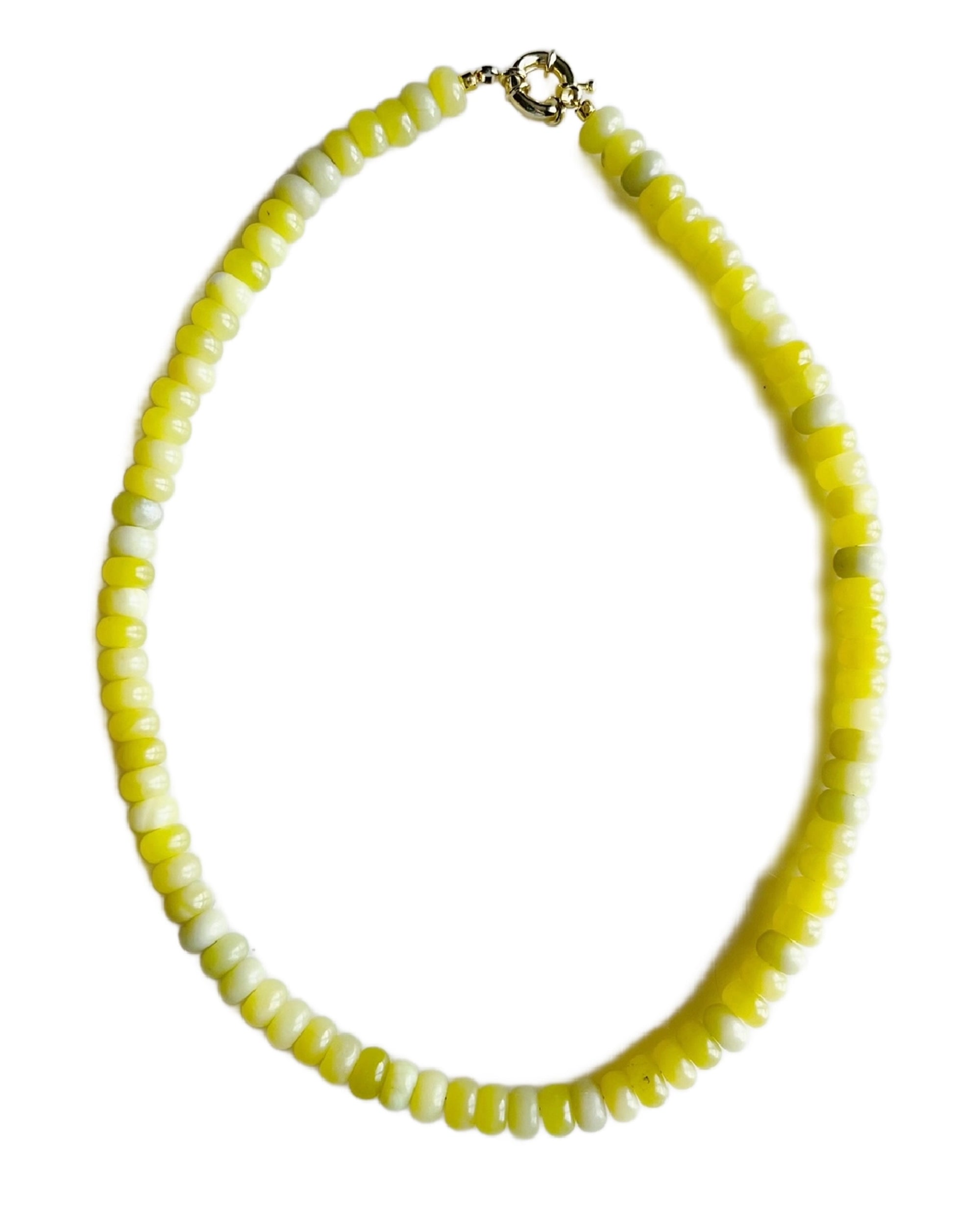 The Faire Lemon Jade Candy Necklace is handmade with round, flat yellow and white gemstone beads and finished with an elegant 18kt gold plated clasp, arranged in a single strand against a white background.