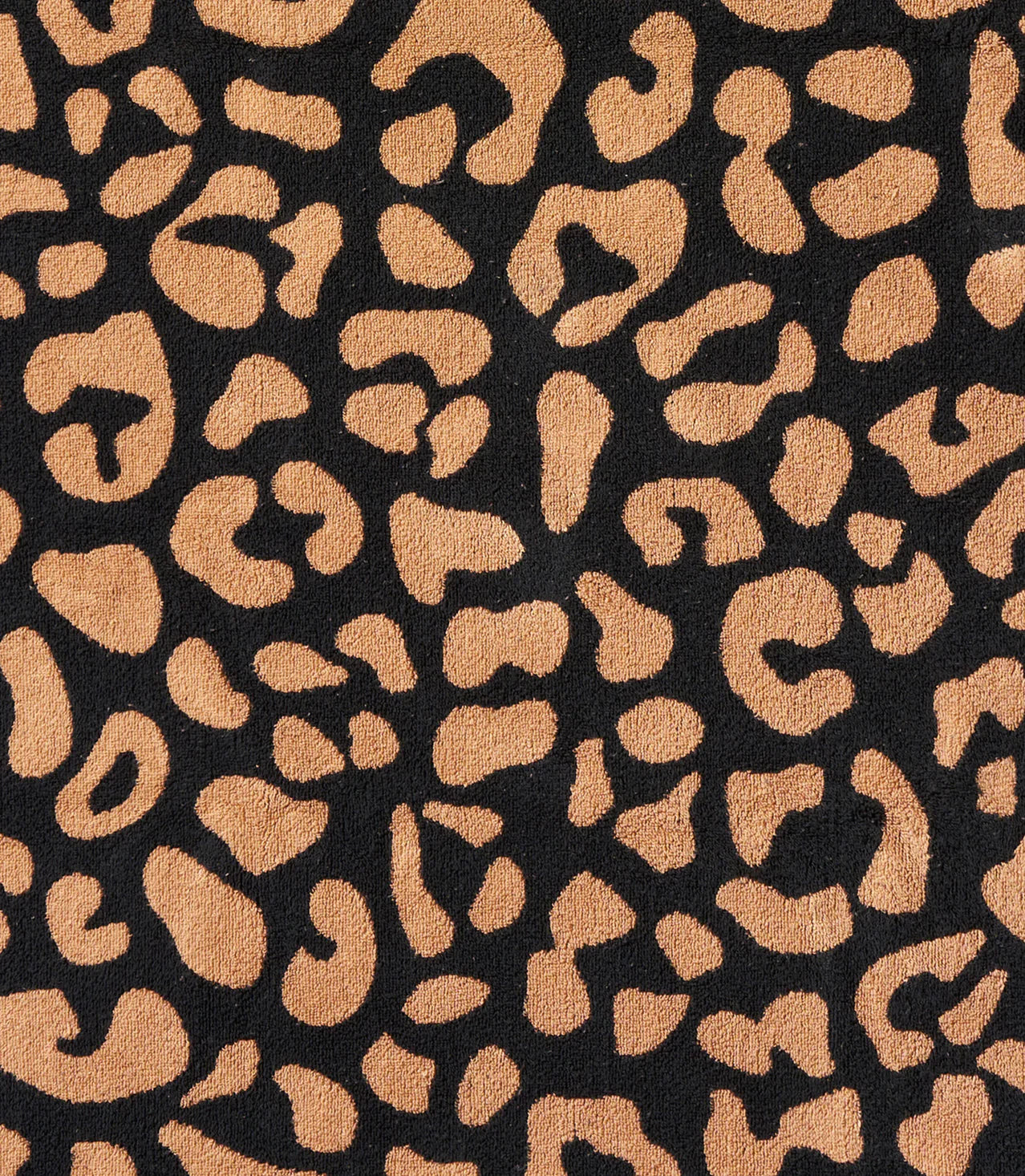 Close-up of Typical’s Wild Leopard Bath Towel fabric, featuring irregular tan spots on a black background for a bold, stylish look.