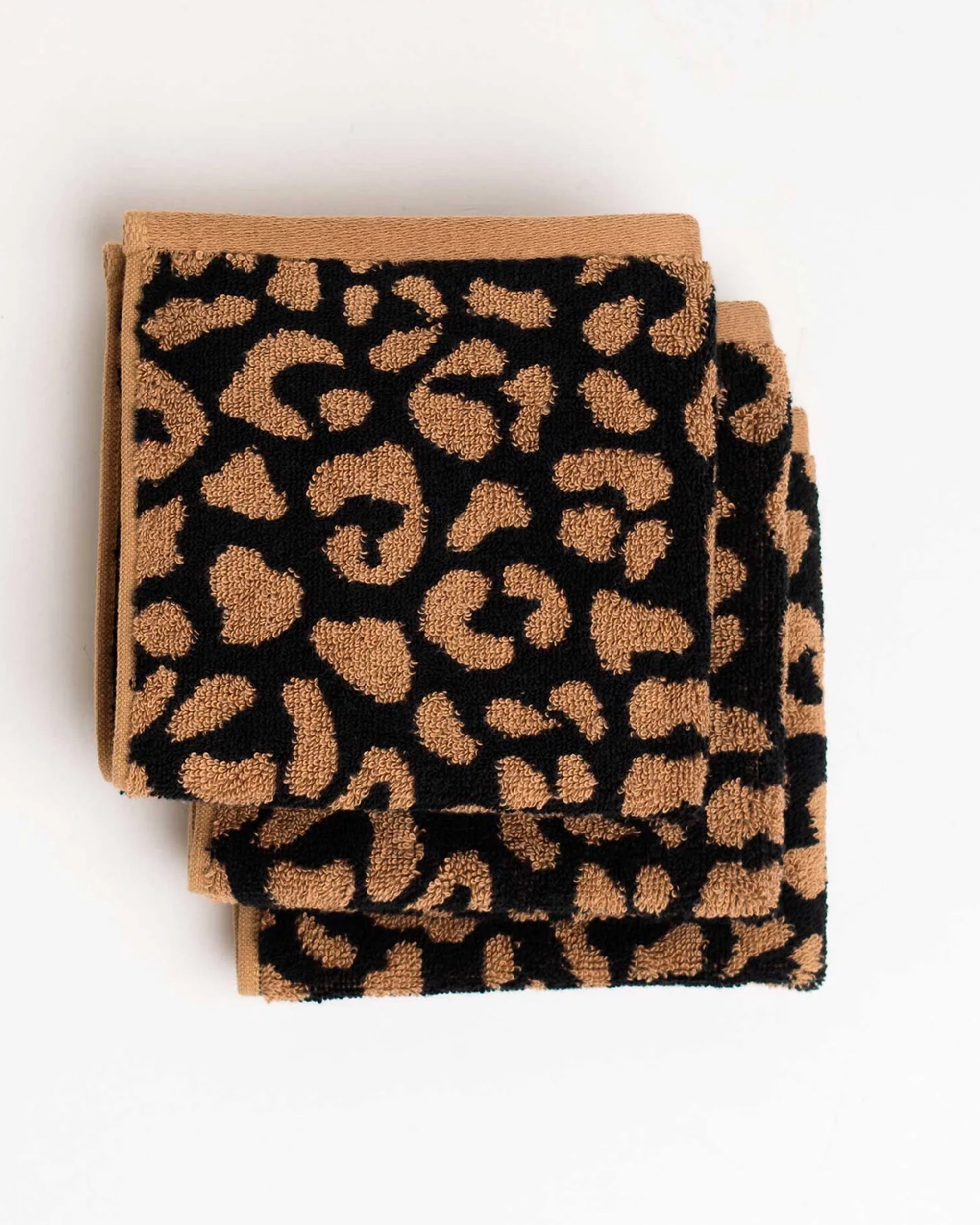 Three Typical Wild Leopard Face Towels featuring a brown and black leopard print are neatly stacked on a white background.