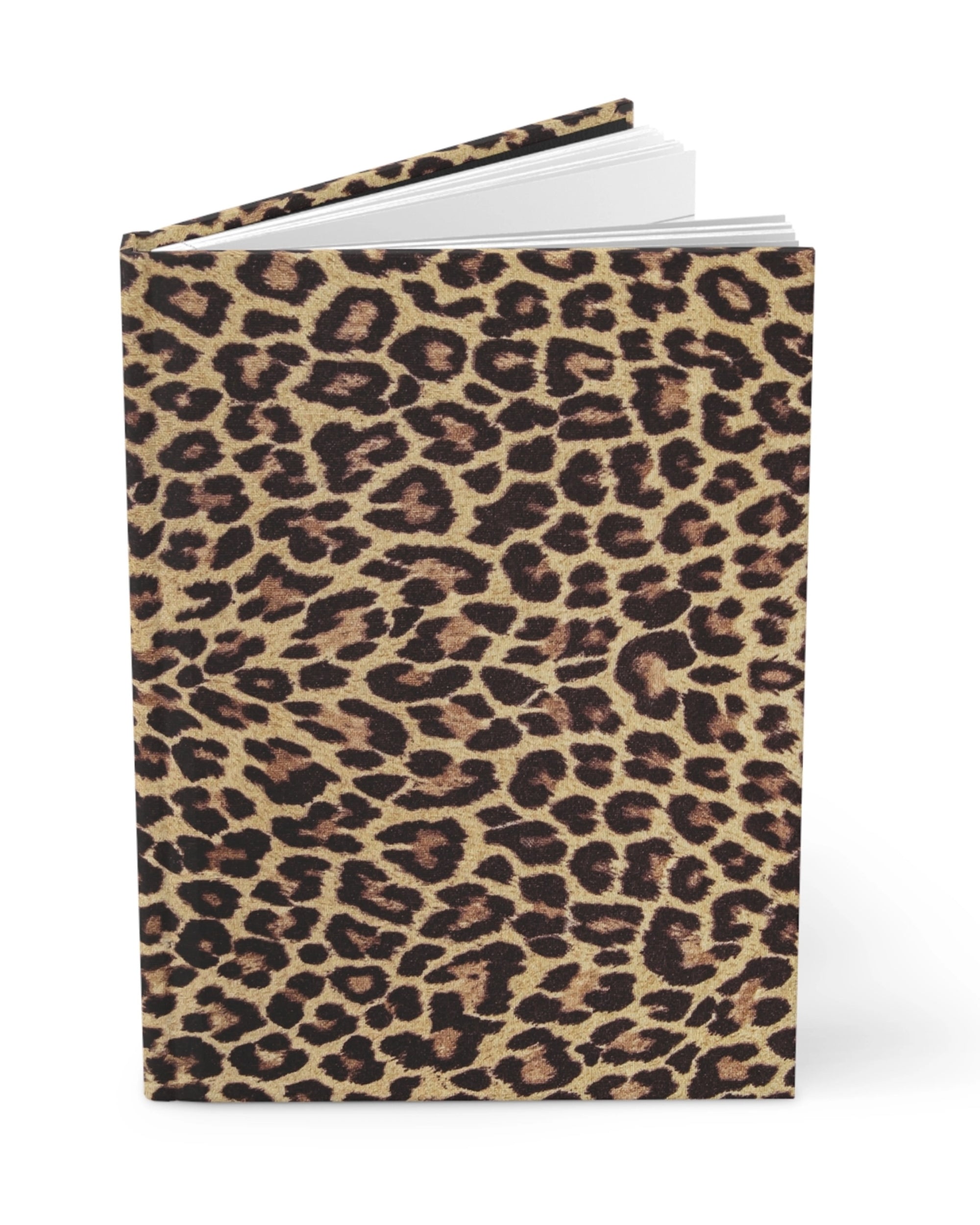 The Faire Leopard Journal stands upright with a bold brown, black, and tan cover. Slightly open, this chic hardcover reveals crisp white pages ready for your notes and ideas.