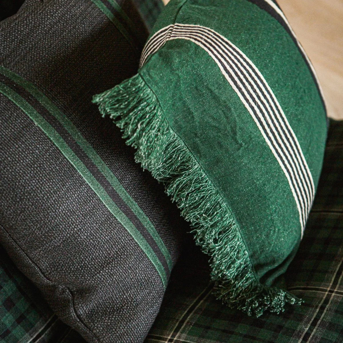 Libeco Home Nell flax linen pillows with chic stripes and fringe on a plaid pattern, perfect for modern living rooms.