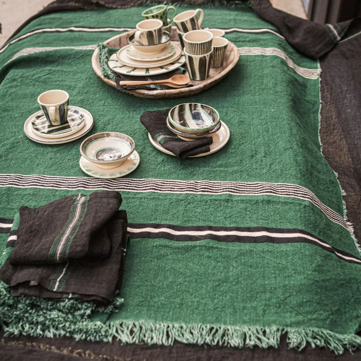 Striped linen tablecloth with plates and napkins, Libeco Home Nell Piece de Lin, styled for a modern dining setting.