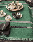 Striped linen tablecloth with plates and napkins, Libeco Home Nell Piece de Lin, styled for a modern dining setting.