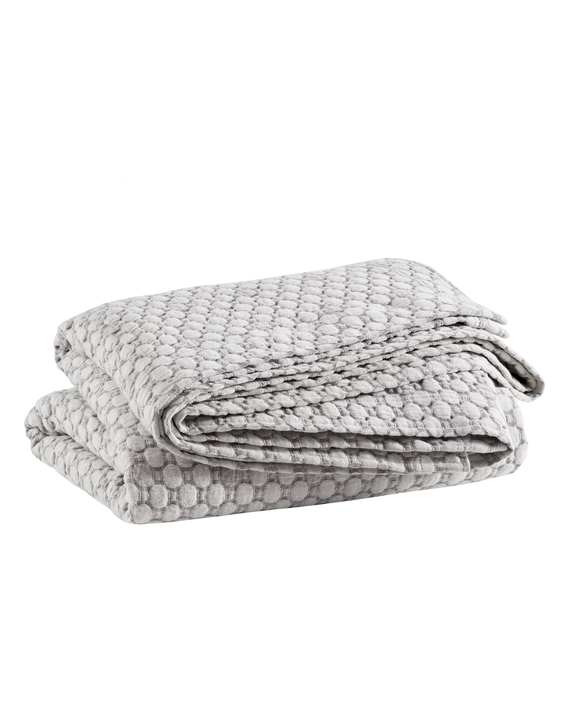 The folded Lodi Matelassé Coverlet by Pinecone Hill features a light gray color, raised dot pattern, and soft cotton layer, displayed on a white background.