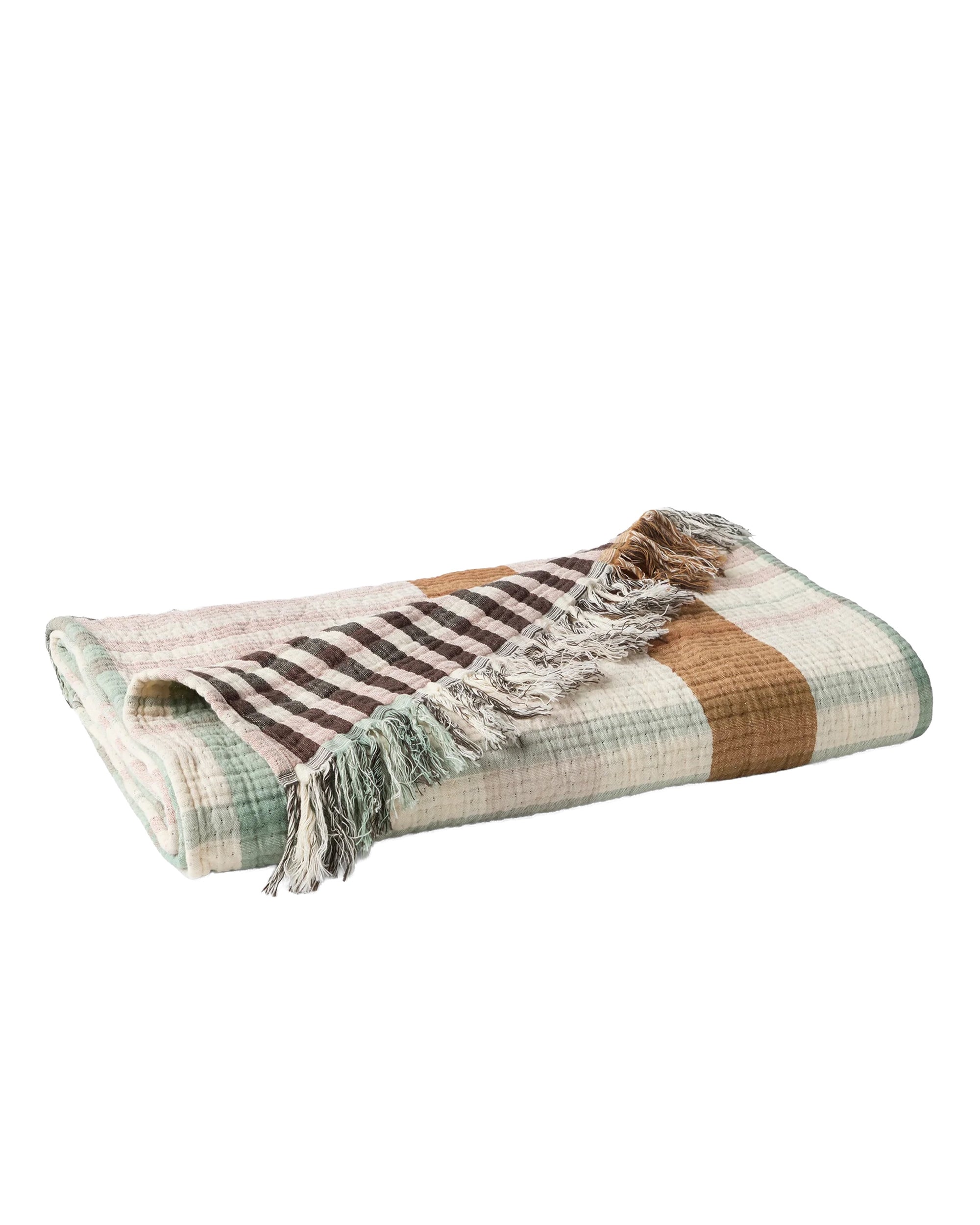 The Loma Matelasse OS Throw by Coyuchi Inc is an oversized plaid throw in brown, beige, white, and light green. Made from organic cotton with a checkered pattern and fringed edges.