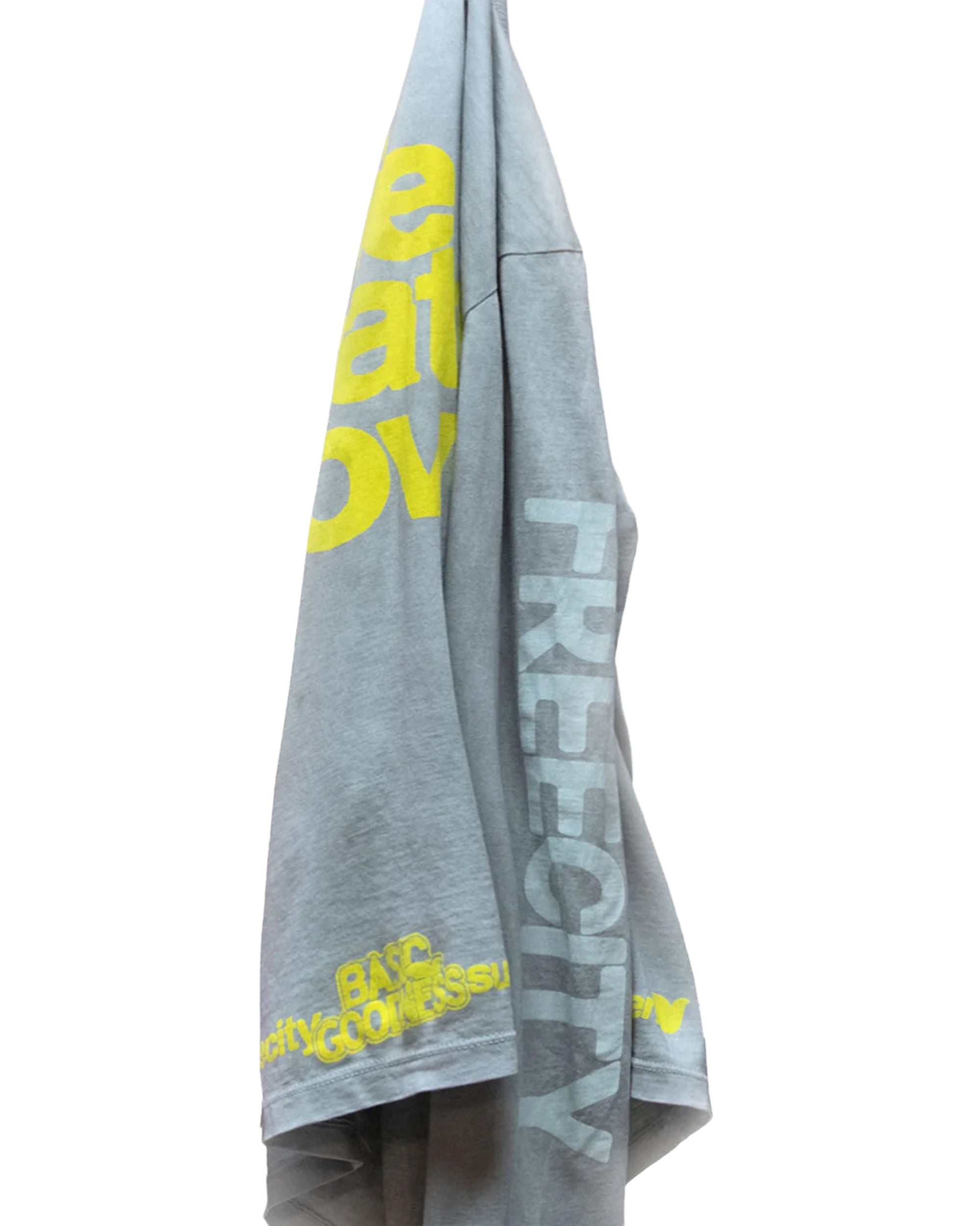 A gray LIFENATURELOVE BG LS Tee by Free City (sparrow, LLC) hangs on a hook against a white background, featuring large yellow and white "FREECITY" text printed vertically plus other partially visible yellow lettering.