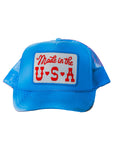 The Faire Made in the USA Patch Trucker Hat features blue mesh, an adjustable snapback, and a white front patch with bold retro red “Made in the U.S.A.” lettering. Photographed on a white background.