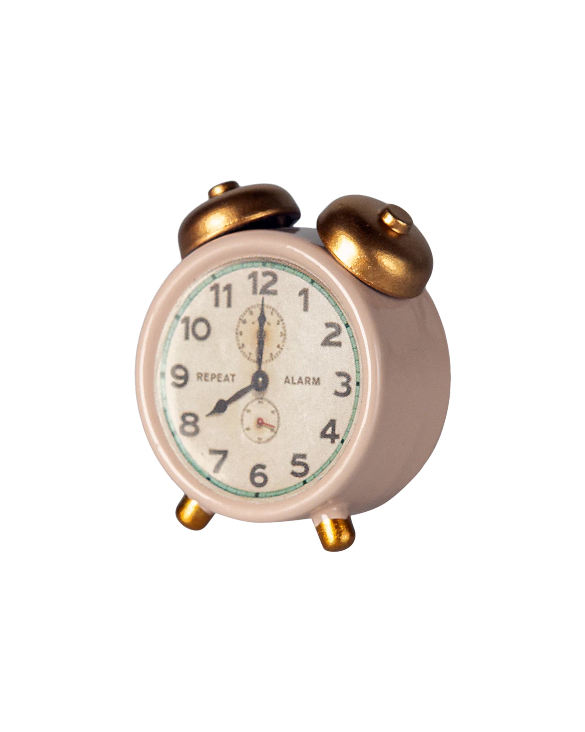 The Maileg Alarm Clock by Maileg is a small vintage-style pink metal clock with gold bells and legs, displaying 12:00, set against a white background.
