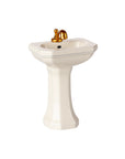 The Maileg Bathroom Sink by Maileg is a small white pedestal sink with a gold faucet, ideal for mouse furniture or dollhouse accessories, shown against a plain white background.
