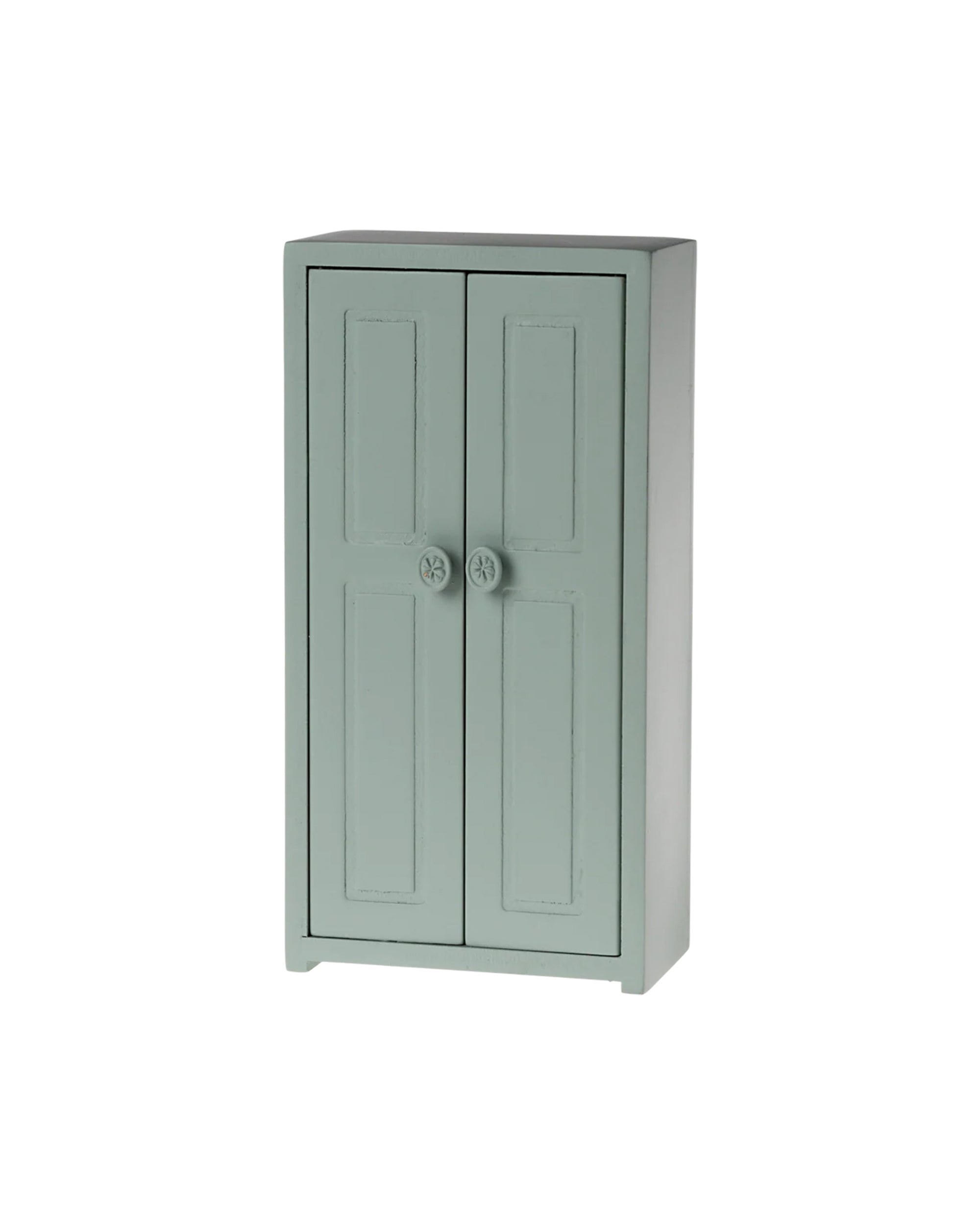 The Maileg Closet by Maileg is a small, light green wooden cabinet with two paneled doors and round knobs, ideal as a mouse wardrobe or organizer, and stands on short legs against a plain white background.