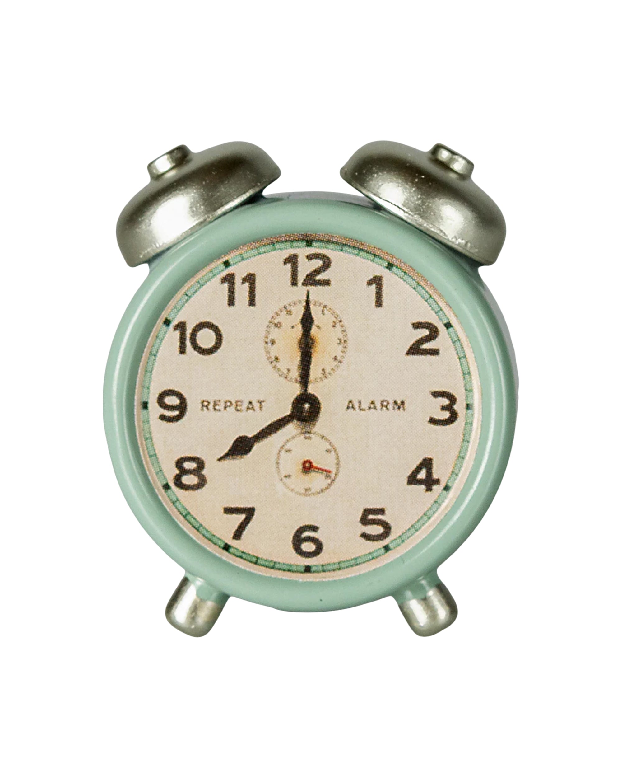 The Maileg Alarm Clock is a small, vintage-style metal clock in mint green with silver bells and legs. It shows 12:00 on a face with black numbers and "REPEAT" and "ALARM" printed.