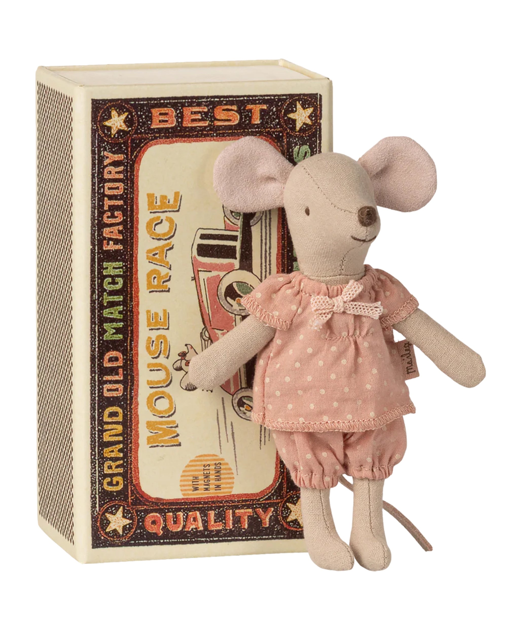 A Maileg Big Sister Mouse doll in a pink polka-dot outfit stands before a vintage-style "Matchbox" toy, set among colorful text and charming illustrations.