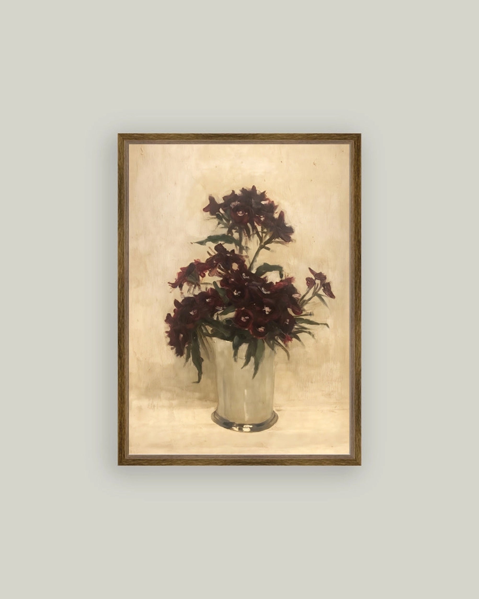 The Maroon Flowers Framed Art by Petal Lane Home showcases dark red flowers with green leaves in a silver vase, set against a light beige backdrop and accented with an ornate frame for a premium look.