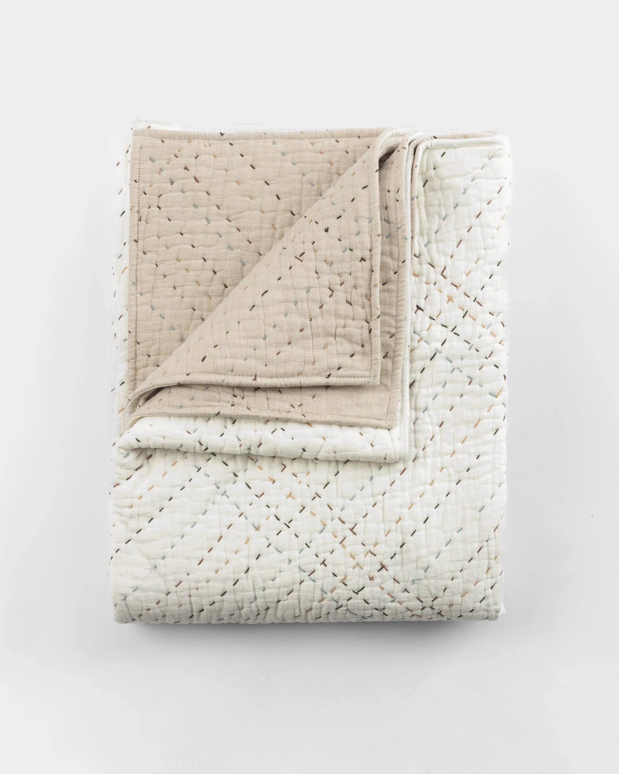 Folded cream and light beige quilt with stitched diamond pattern, Amity Home Mendel collection, handmade style.