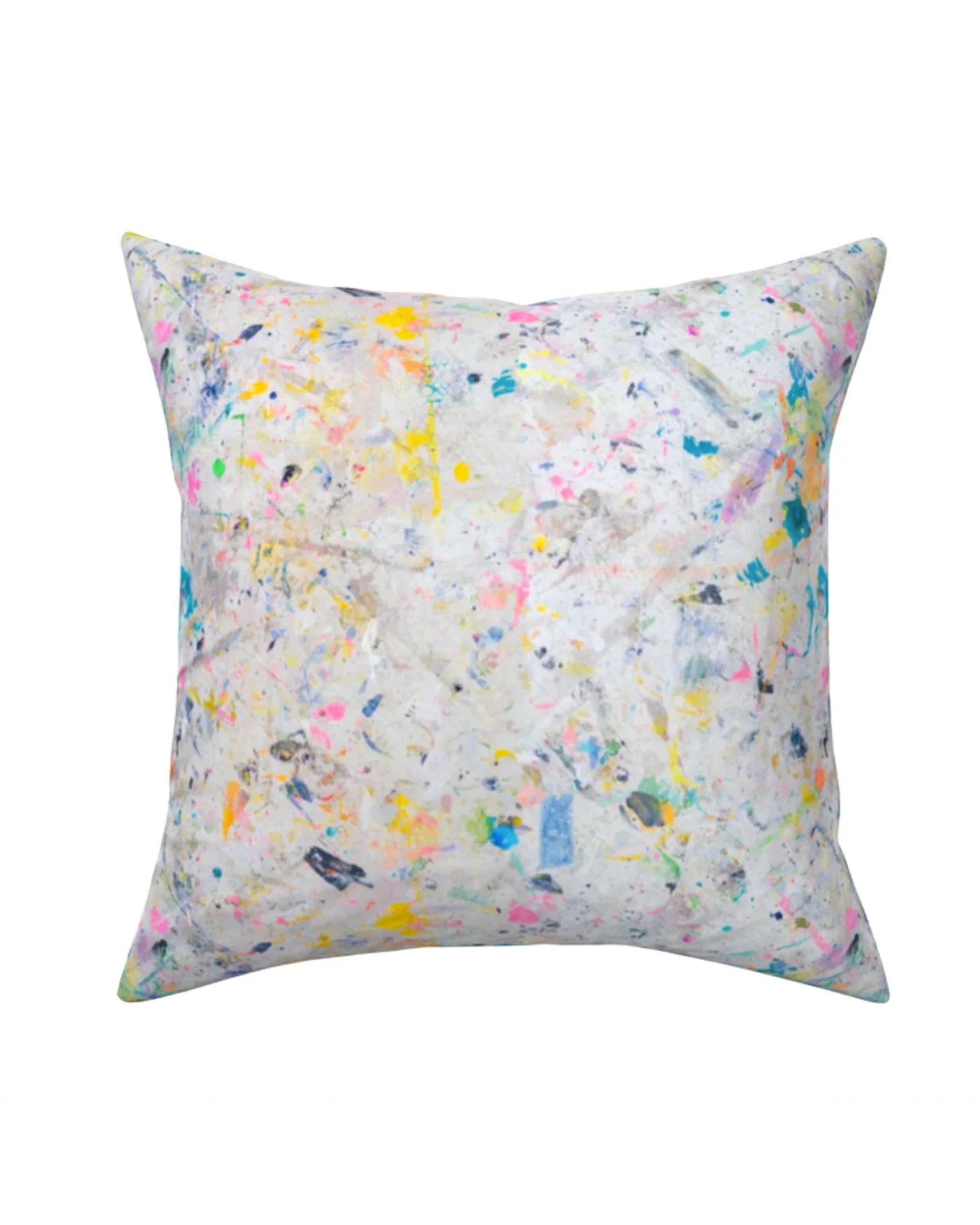 The Kerri Rosenthal Messy Pillow is a square Belgian linen throw pillow with a white background and an abstract splatter pattern in pastel and neon pink, yellow, blue, and gray, evoking the brand’s playful signature style.