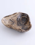 Small triangular bowl in polished brown and beige onyx by Faire, with swirling stone patterns, shallow profile.