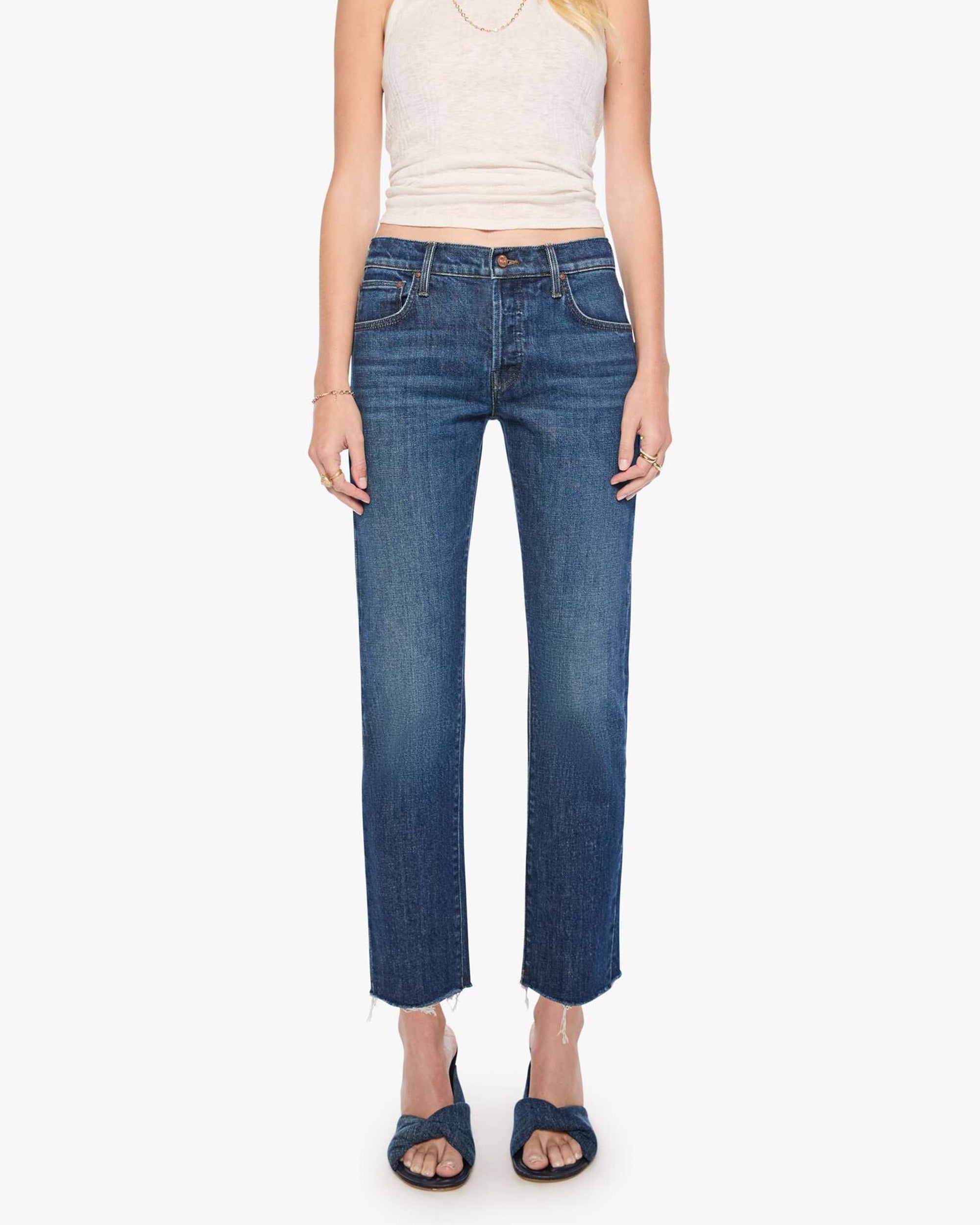 Mother’s dark blue Mid Rise Hiker Hover fray jeans styled with a white tank and dark sandals on a clean backdrop.