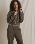 Olive Milana Track Jacket by Perfectwhitetee, modeled in front of a light beige fabric backdrop.