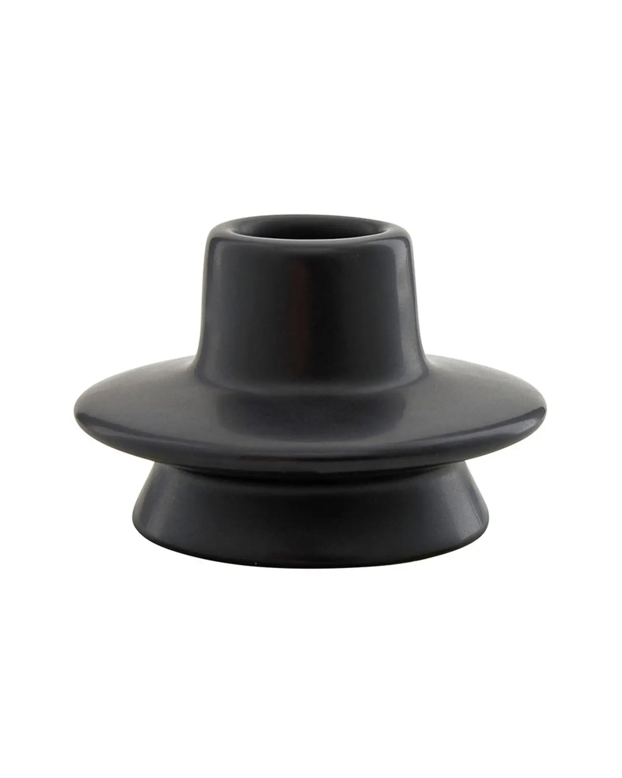 The Faire Mini Black Taper Holder features a wide, flat base and cylindrical center, making it a chic modern candleholder for taper candles. Shown against a white background.