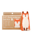A Faire Fox Embroidery Kit is shown in a brown box with white text and a Kiriki-pattern fox. Next to it sits a finished plush orange and white embroidered fox doll.