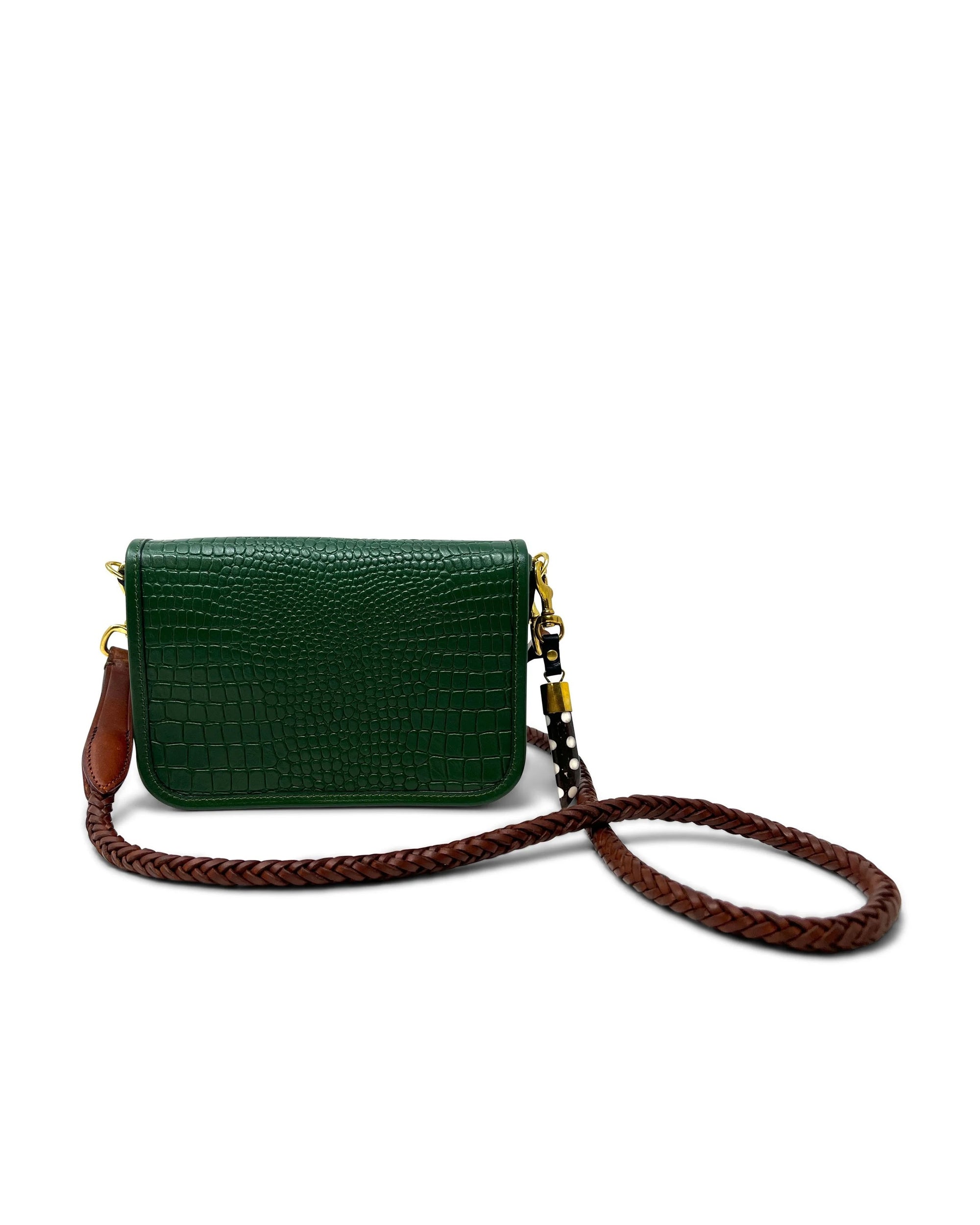 The Kempton & Co. Mini Mia Crossbody is a small forest green clutch featuring a textured crocodile-style pattern and a long braided brown strap, shown against a white background.