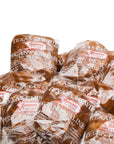 LC Pecan Pralines 1oz by Faire come stacked in clear packaging, each piece individually wrapped with white printed labels—ideal for anyone looking for bulk pralines with a rich, classic flavor.