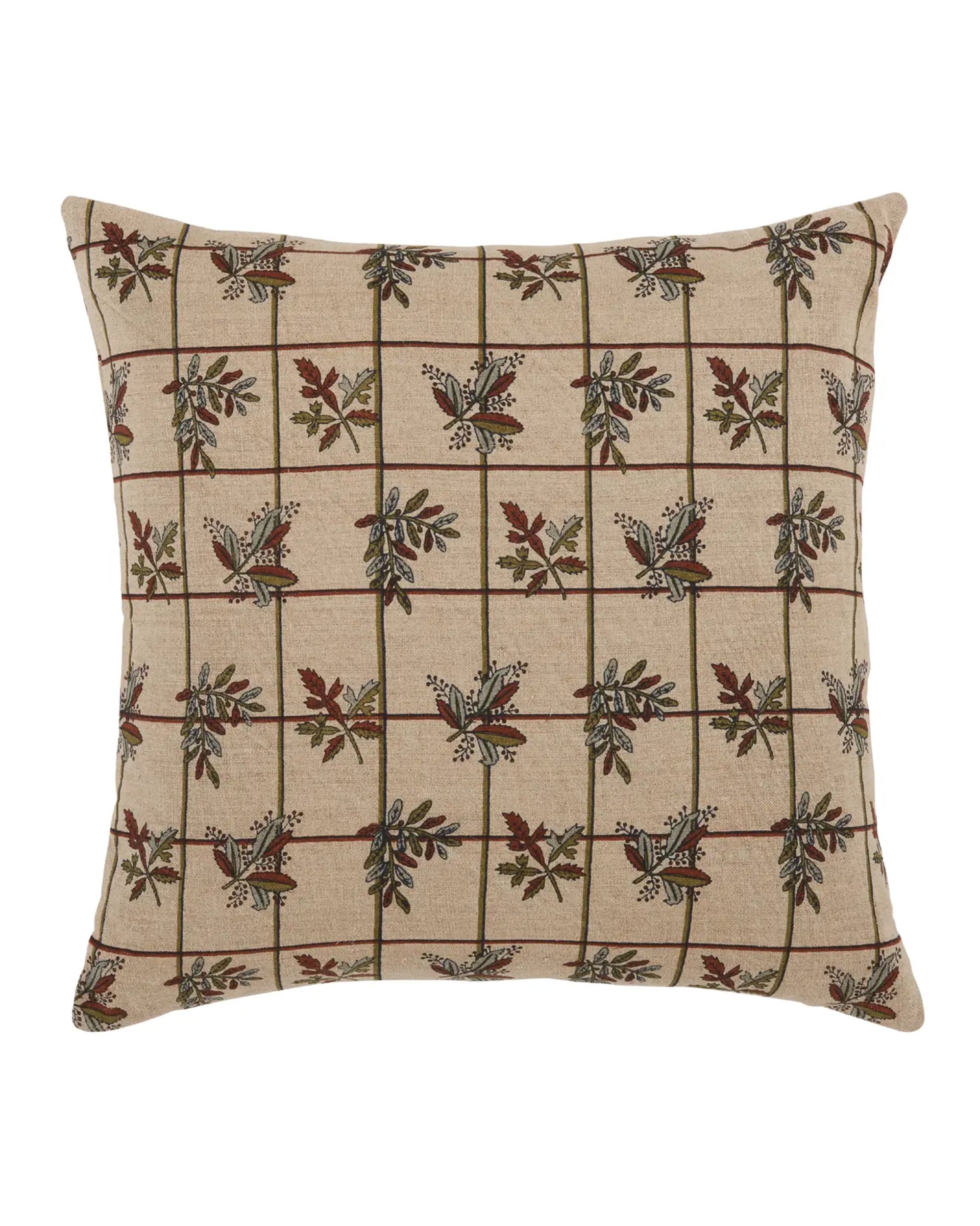 The Liam & Lana Mirabelle Pillow 22x22 is a square beige throw pillow with a grid pattern and subtle floral and leaf motifs in earthy tones, offering a symmetrical design that adds charm to any home decor.