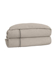 The Moab Textured Comforter by Eastern Accents features decorative edge stitching and soft poly batting in a neatly folded beige linen design, displayed on a white background.