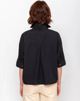 Black Monday12 Daria Shirt and beige pants from back, styled on model with short brown hair.