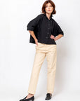 Black Daria Shirt by Monday12 styled with beige pants, modern look against a white background.