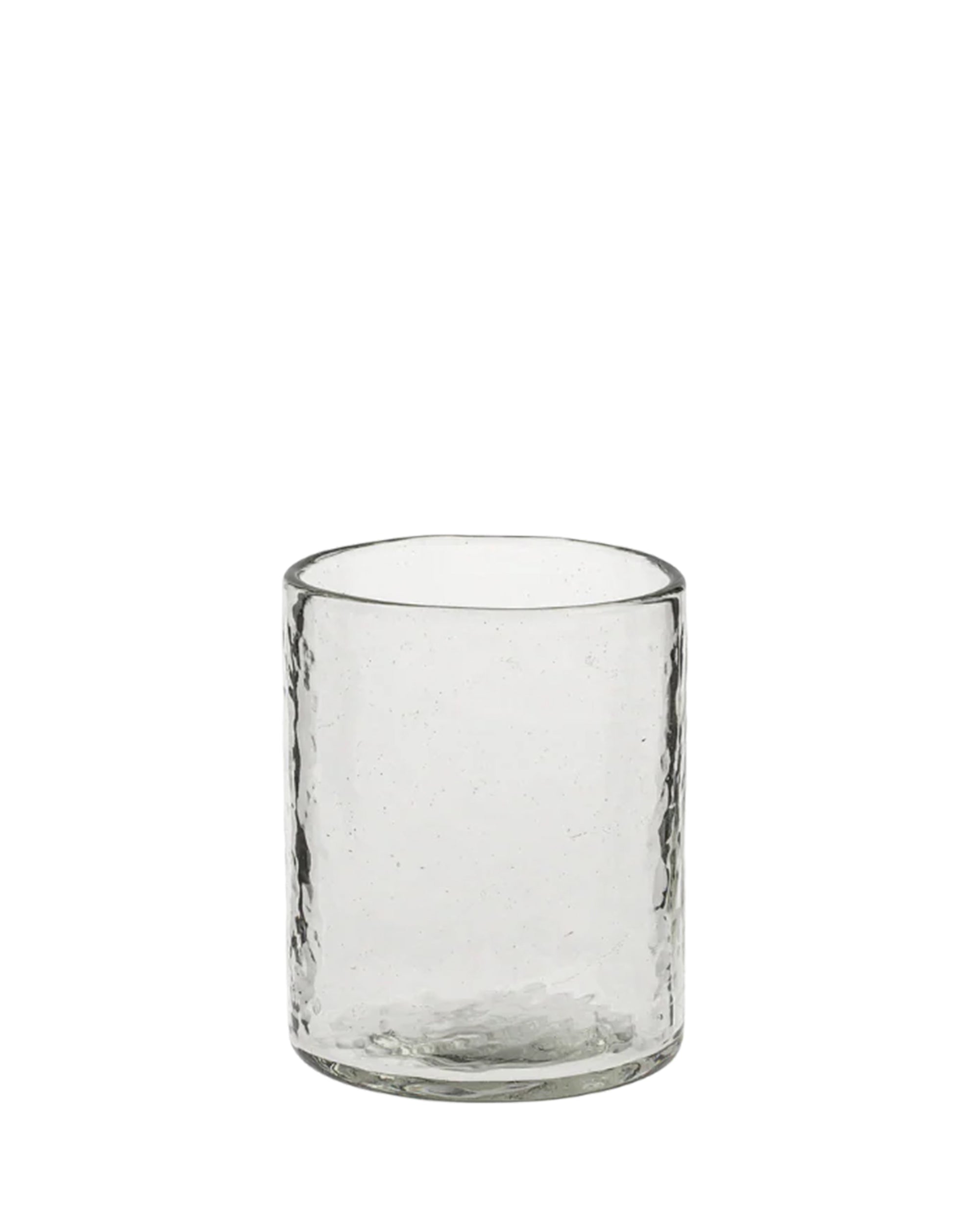 The Indaba 4-7505 Montenegro Tumbler is a clear, cylindrical glass with a slightly textured surface, handcrafted in India from handblown glass. Shown on a plain white background.
