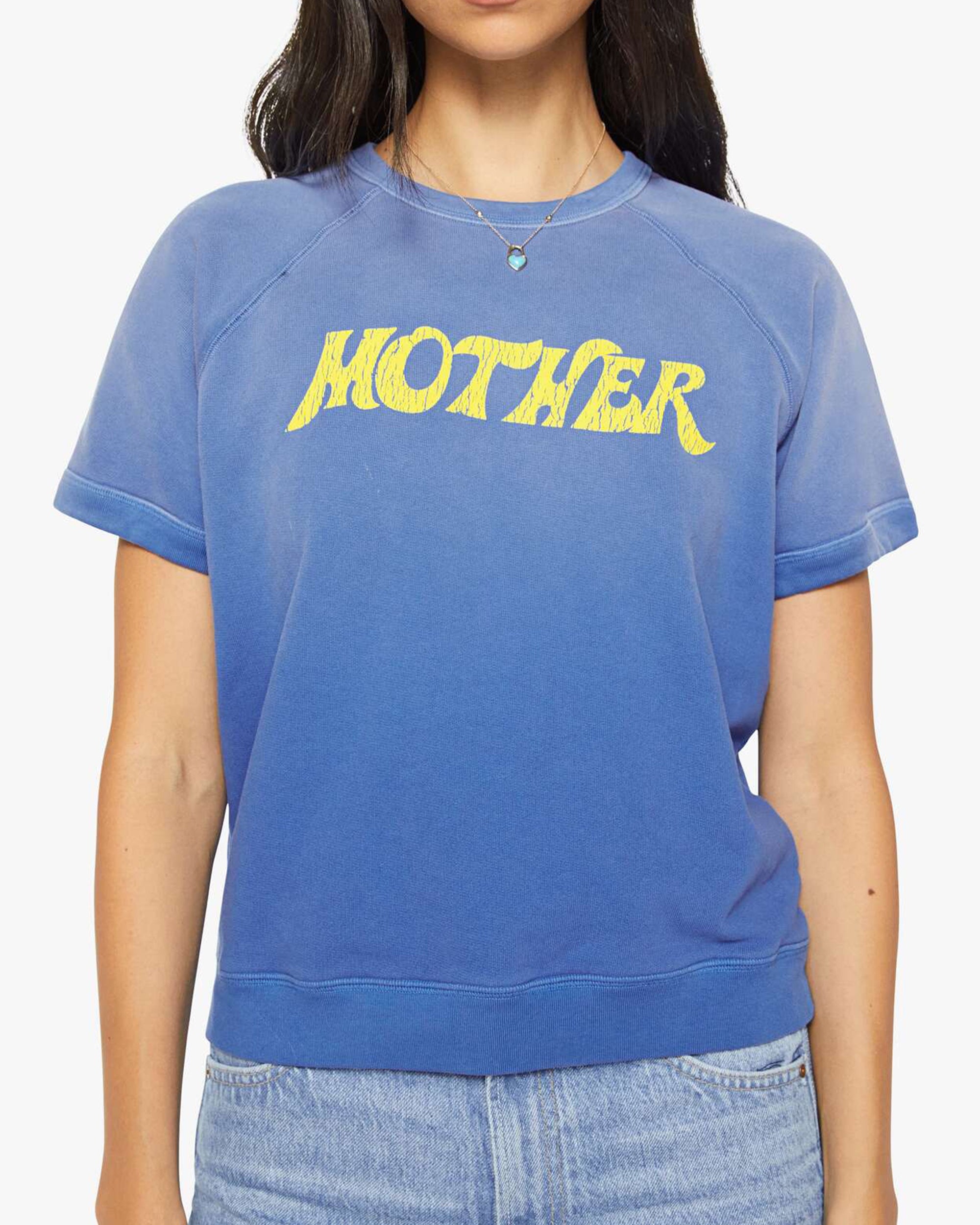 A person wearing The Short Sleeve Concert Tee by Mother, styled with light blue jeans.