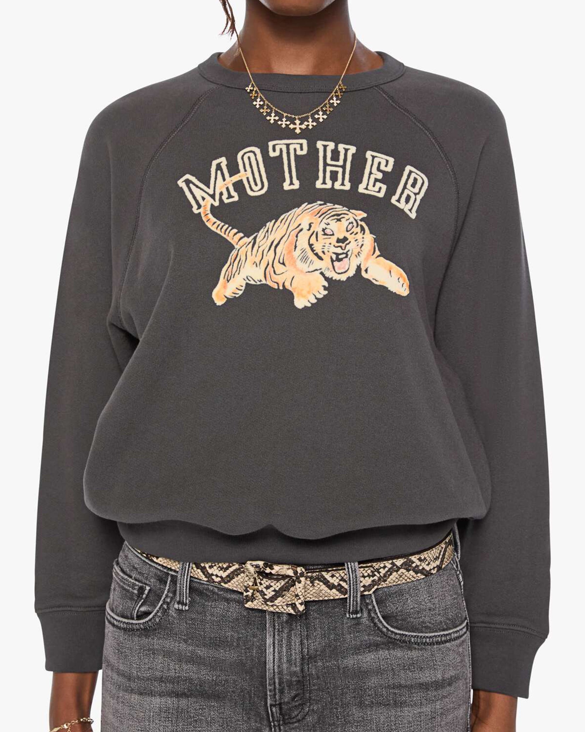 The Concert sweatshirt by Mother paired with cropped jeans and a snake-print belt for a casual, modern look.