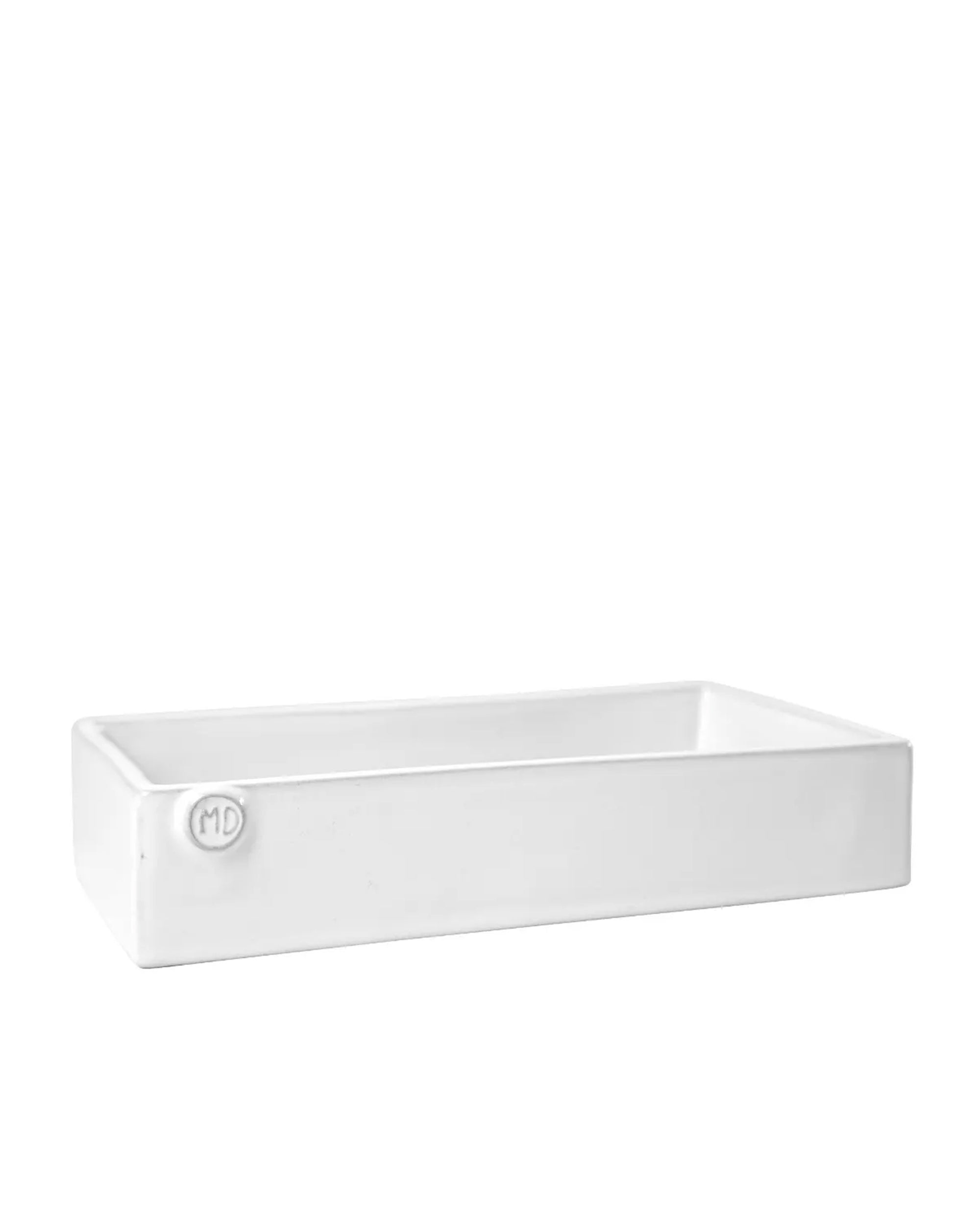 The Montes Doggett Napkin Holder L NO. 808 is a rectangular, white high-fired ceramic tray with raised edges and a small circular "MD" logo embossed on one corner. Dishwasher safe for easy cleaning.