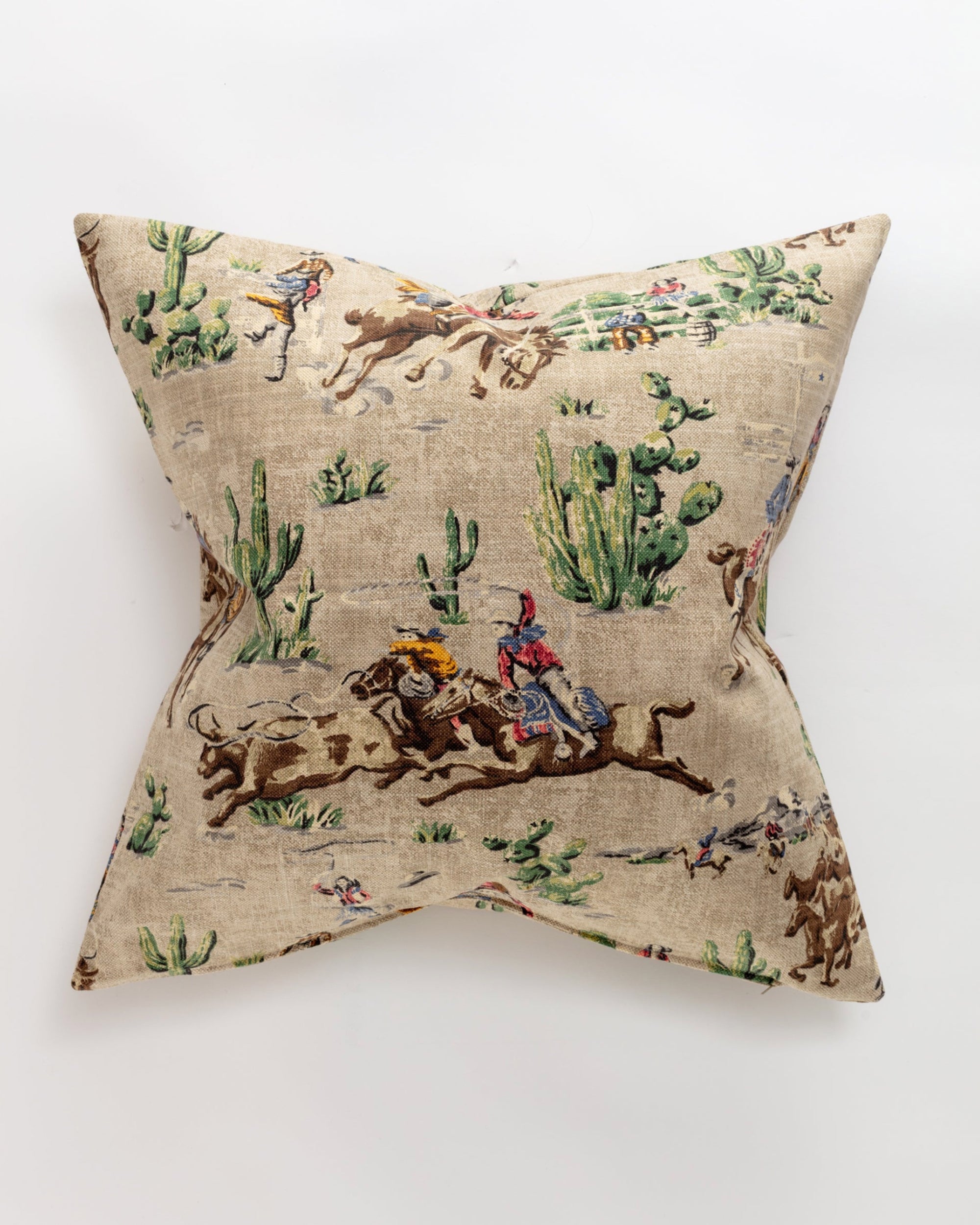 The Cowboys 26x26 Pillow by Pindler features beige fabric adorned with a Western cowboy and cactus print, adding unique rustic charm to any space.