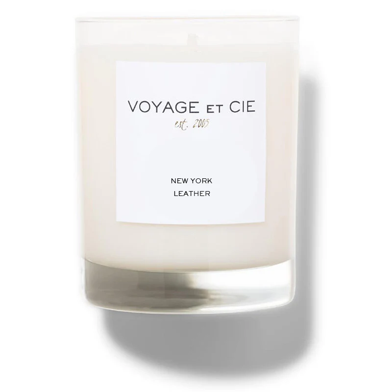 A 14 OZ Classic Highball soy coconut blend candle by Voyage Et Cie in a clear glass with a white "VOYAGE ET CIE est. 2005 NEW YORK LEATHER" label, unlit and displayed against a plain white background.