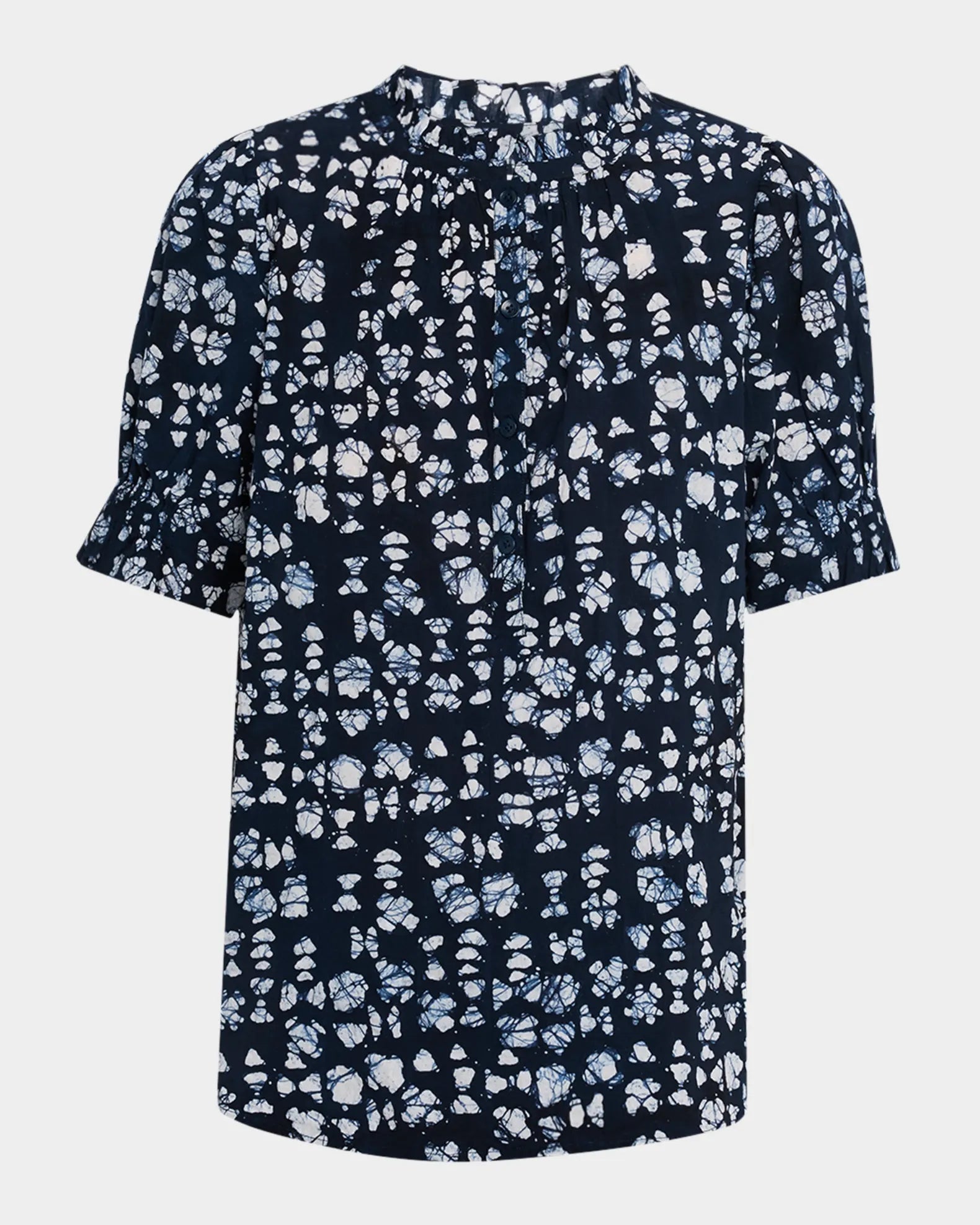 The Apiece Apart Los Altos Top is a navy blouse with a white abstract print, short ruffled sleeves, high round pleated neckline, and relaxed fit.