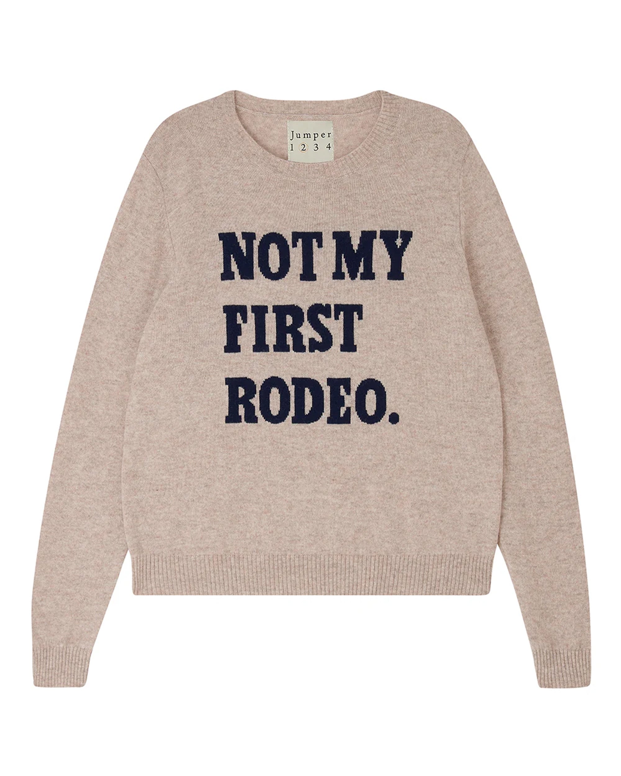 The Rodeo Crew by Jumper 1 2 3 4/CR2 is a beige crew neck sweater featuring "NOT MY FIRST RODEO." boldly printed in navy blue across the front.