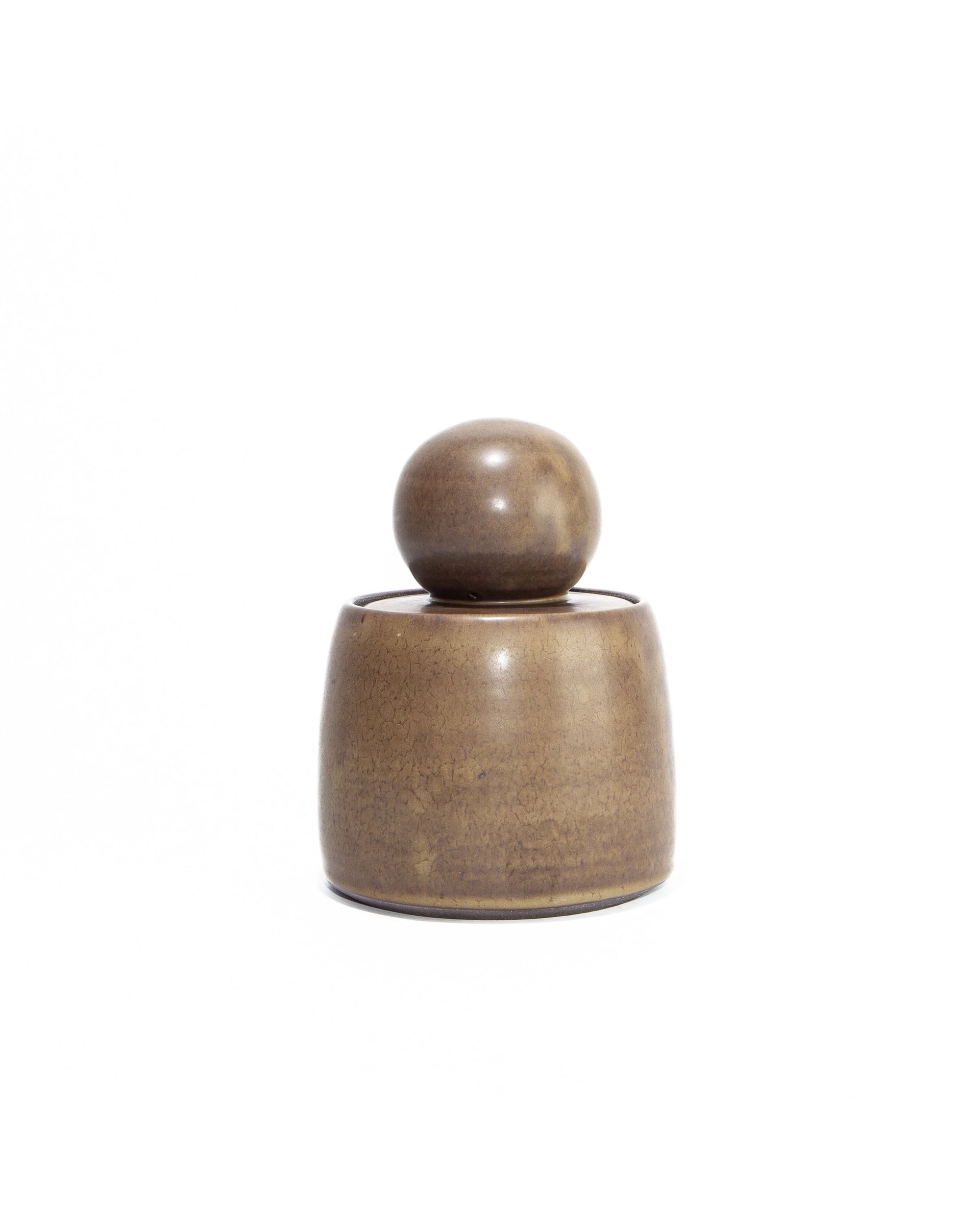 The Faire Olive Brown Stash Jar is a small, round, hand-thrown jar with a matching spherical lid, shown against a plain white background.