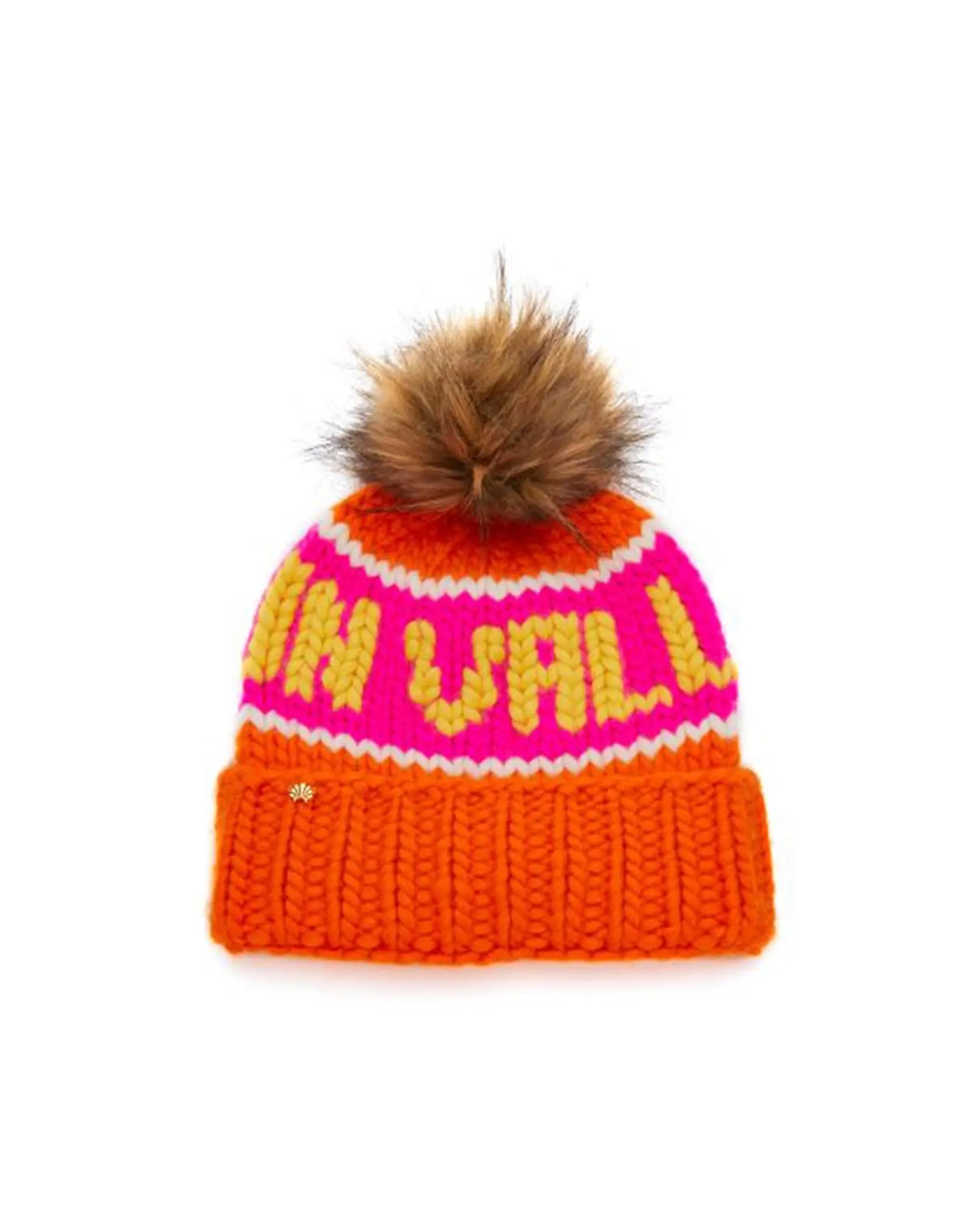 The Faire Knit Ski Hat is a luxury merino wool beanie with a brown faux fur pom-pom, an orange cuff, a pink top, and yellow text.