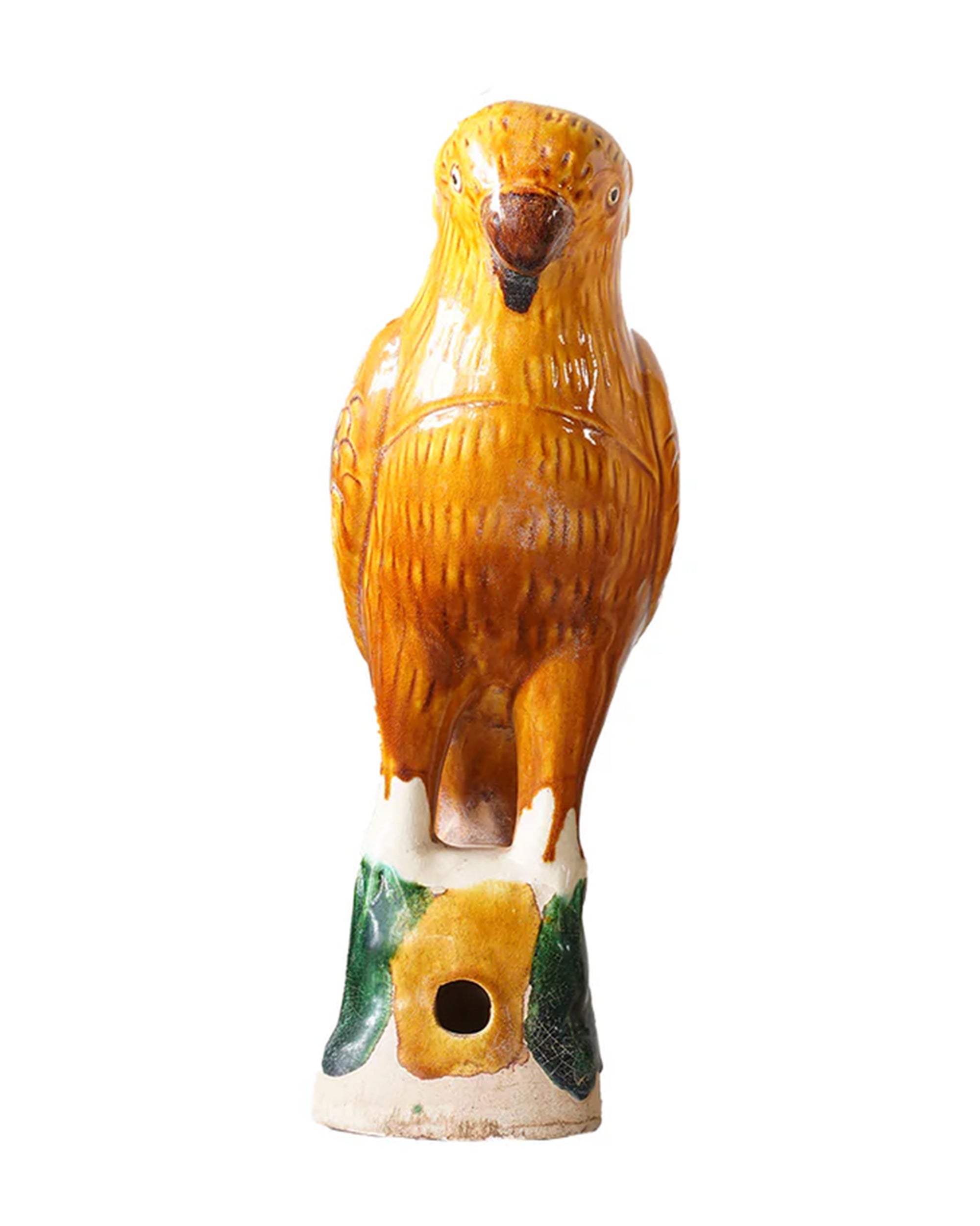 The Parrot Small by Blue Ocean Traders is a ceramic sculpture inspired by Jingdezhen Hand-Painted Porcelain, glazed in yellow and brown, perched on a green and white base with a hole near the bottom, set against a white background.